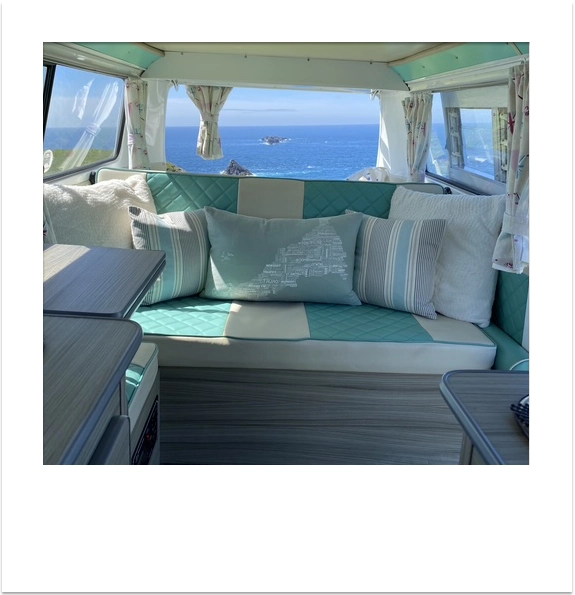 View of the sea from the back seat of a vintage VW campervan.